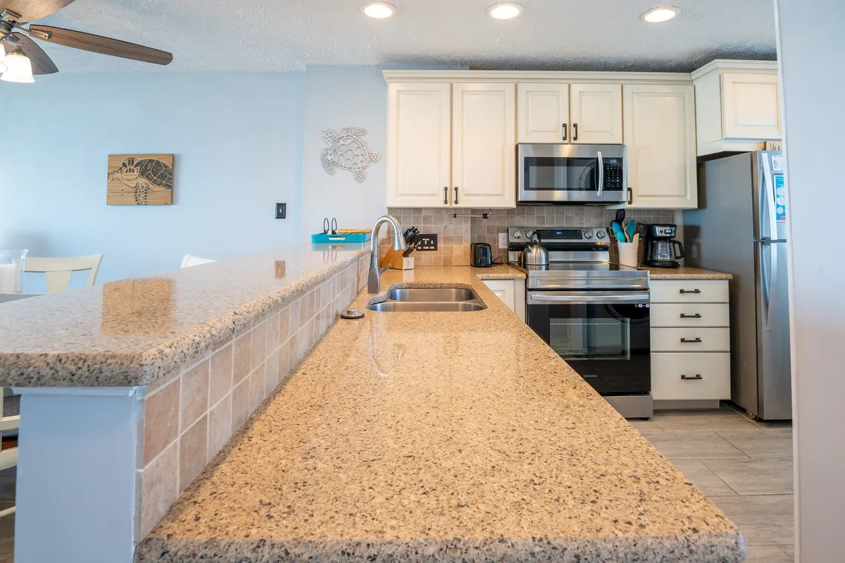 A modern, well-equipped kitchen with sleek granite countertops, stylish cabinetry, and stainless steel appliances. The bright, cheerful mood makes it ideal for preparing meals and entertaining guests.